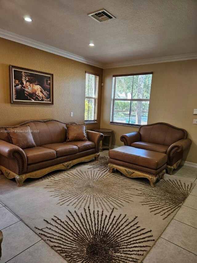 living room with ornamental molding, a notable chandelier, and tile patterned flooring