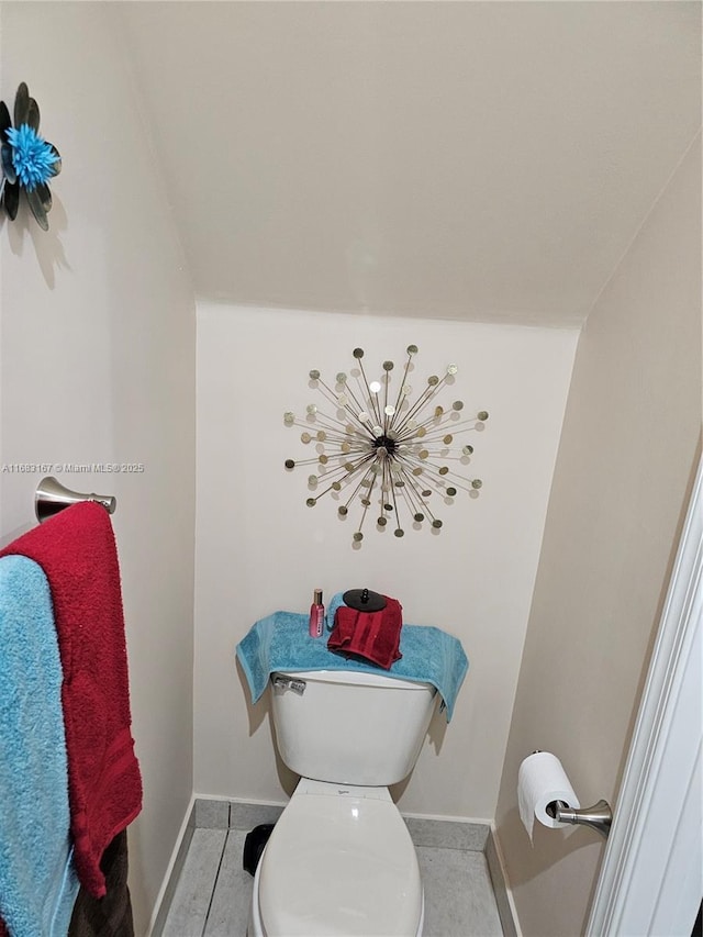 bathroom featuring toilet, tile patterned flooring, and lofted ceiling