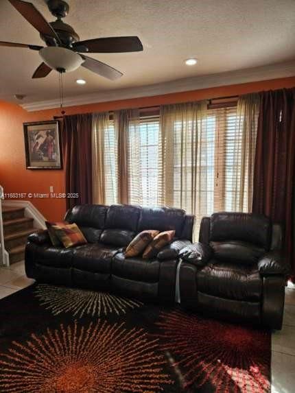 carpeted bedroom featuring a raised ceiling, crown molding, and ceiling fan