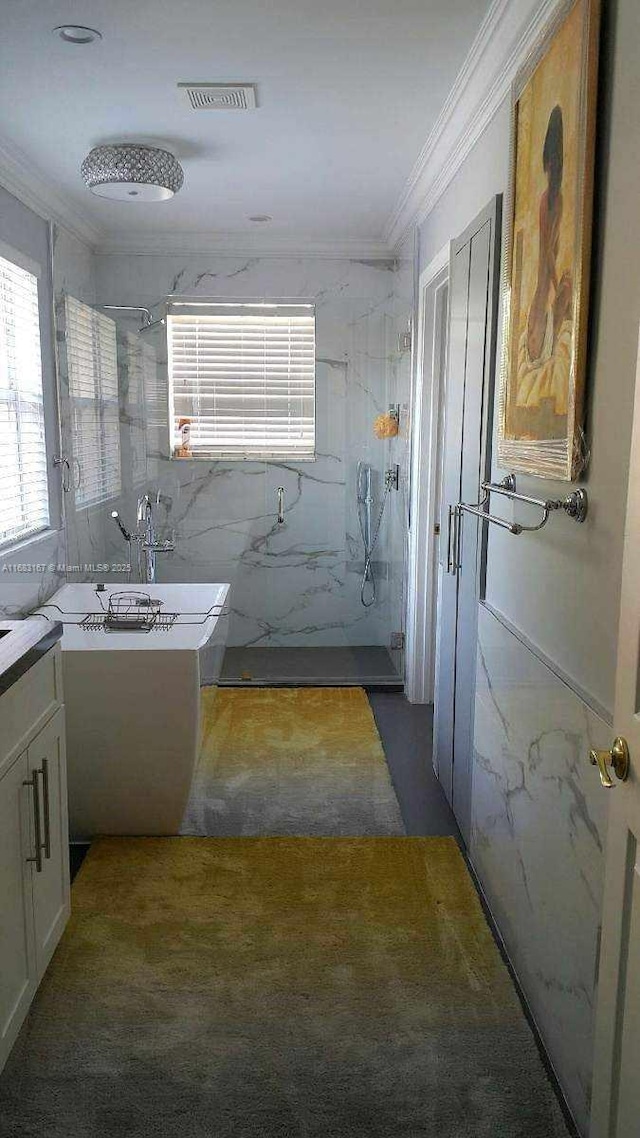 bathroom with a tile shower, crown molding, vanity, and tile walls