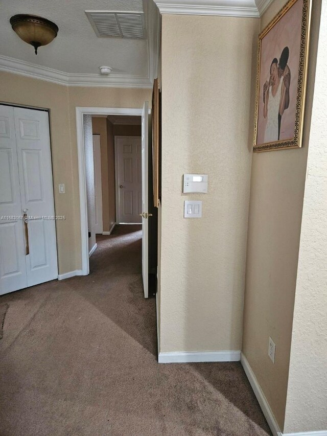 hallway featuring dark carpet and ornamental molding