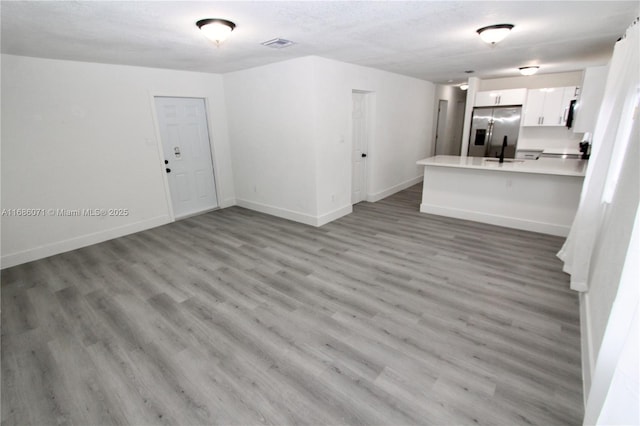 unfurnished living room featuring a textured ceiling and hardwood / wood-style floors