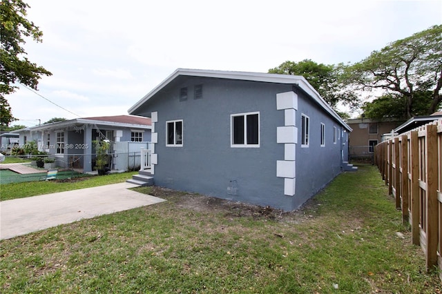 view of side of property featuring a yard and a patio area