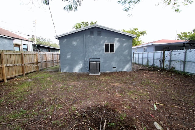 back of property featuring an outdoor structure and central AC unit