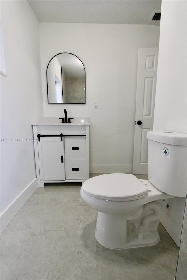 bathroom featuring toilet and vanity