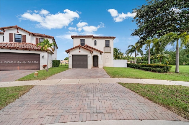 mediterranean / spanish-style home featuring a front lawn and a garage