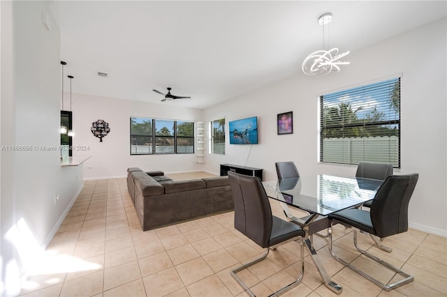 tiled dining area with ceiling fan with notable chandelier