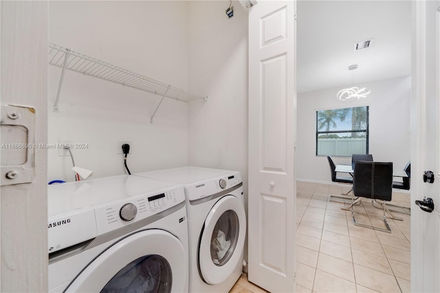 laundry room with washing machine and clothes dryer and light tile patterned floors