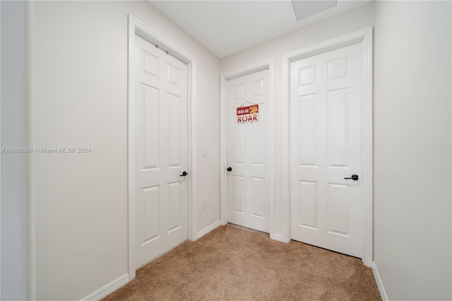 hallway featuring light colored carpet