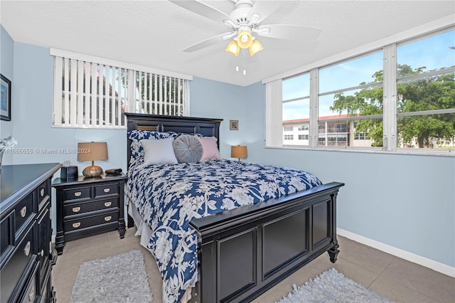 tiled bedroom with a textured ceiling and ceiling fan