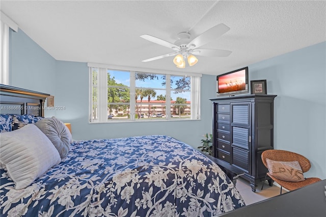 bedroom with ceiling fan, tile patterned floors, and a textured ceiling