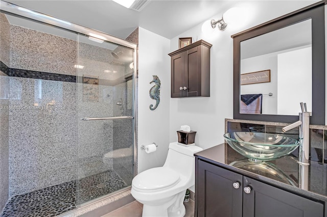 bathroom featuring vanity, toilet, and a shower with door