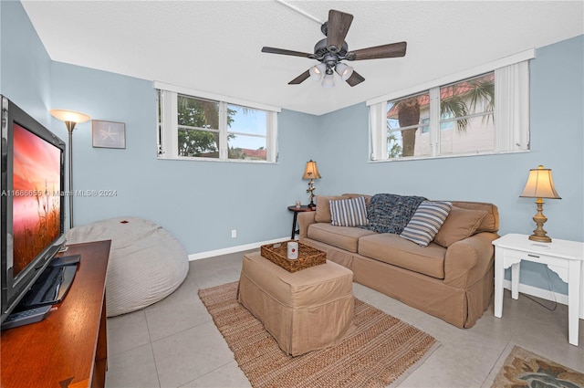 tiled living room with a textured ceiling and ceiling fan