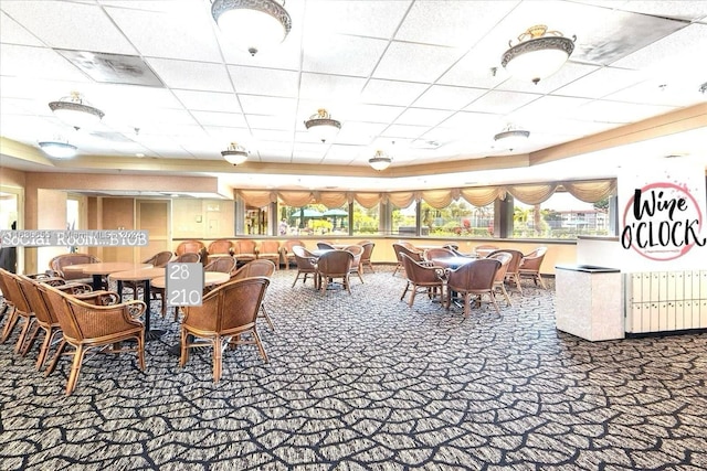 dining space featuring a drop ceiling and carpet flooring