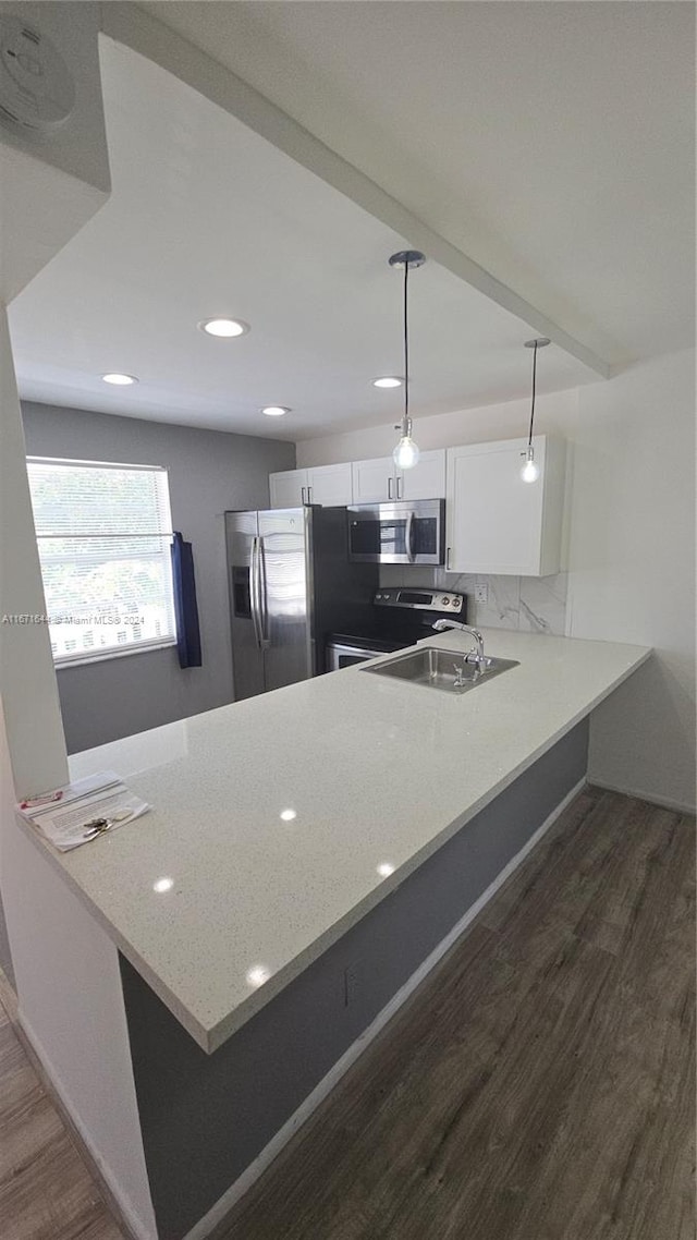 kitchen with kitchen peninsula, white cabinets, decorative light fixtures, and stainless steel appliances