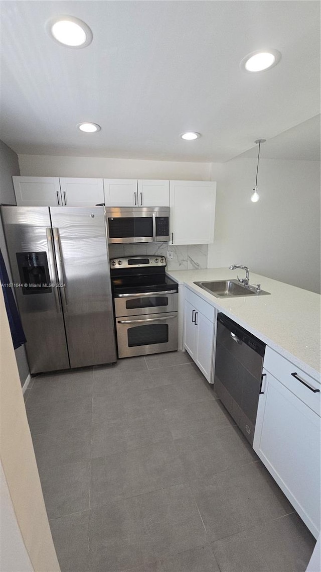 kitchen with backsplash, appliances with stainless steel finishes, sink, and white cabinets