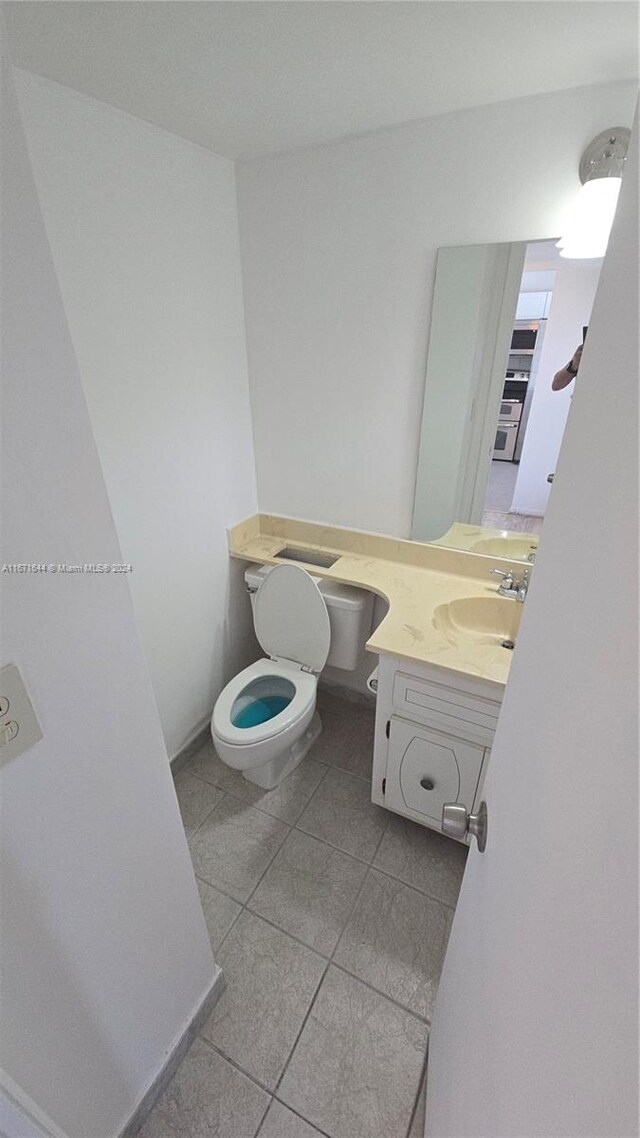 bathroom featuring vanity, toilet, and tile patterned flooring