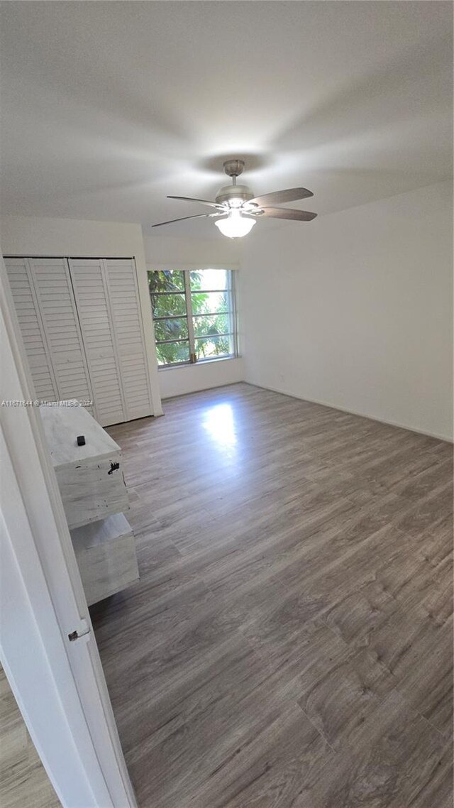 unfurnished bedroom featuring a closet, ceiling fan, and wood-type flooring