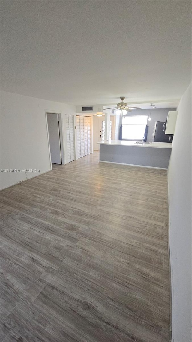 empty room with a textured ceiling, wood-type flooring, and ceiling fan