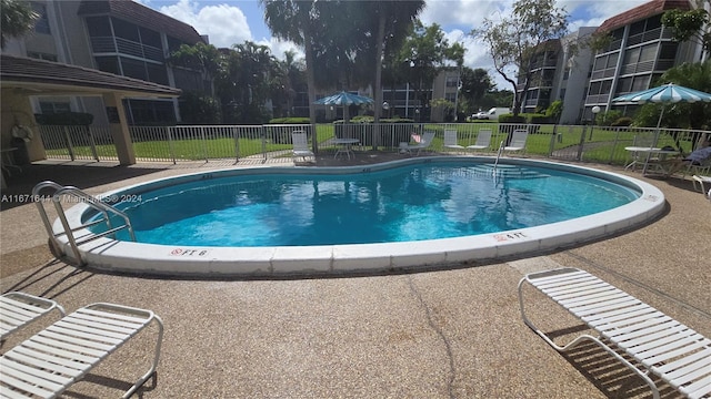 view of swimming pool with a lawn