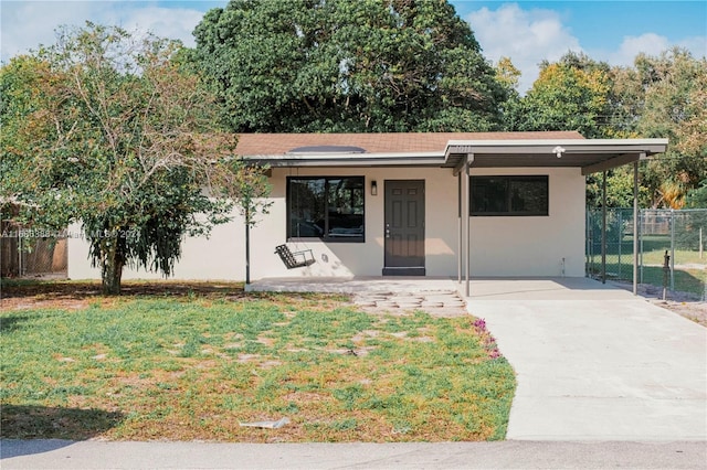 view of front of home with a front yard and a carport