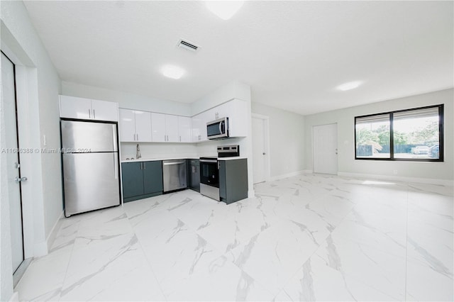 kitchen featuring sink, appliances with stainless steel finishes, a textured ceiling, and white cabinets