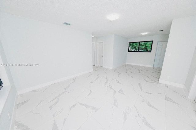 unfurnished room featuring a textured ceiling