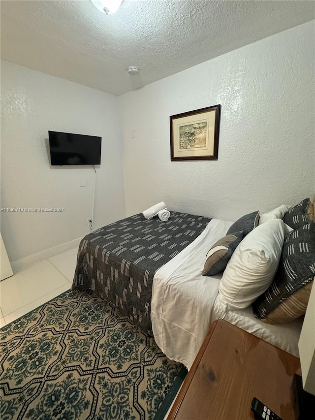 bedroom with a textured ceiling and tile patterned flooring