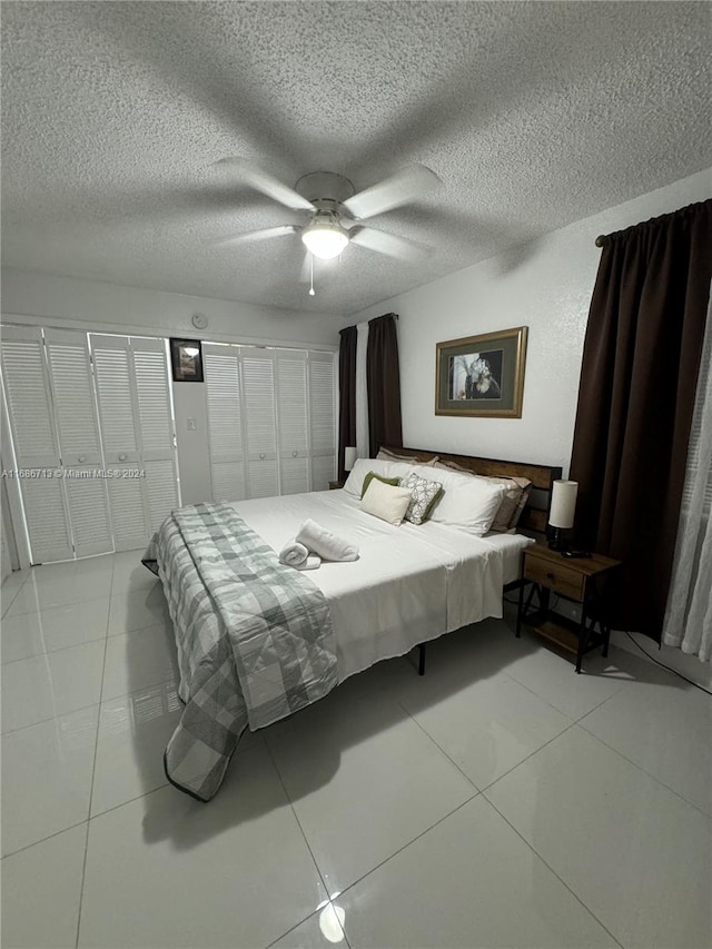 tiled bedroom featuring a textured ceiling and ceiling fan