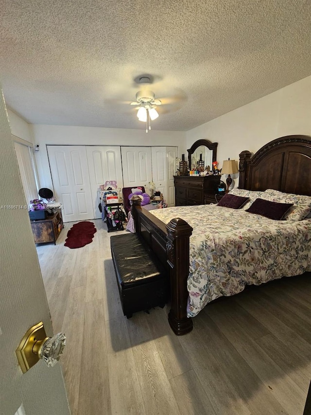 bedroom featuring ceiling fan, light hardwood / wood-style floors, and a textured ceiling