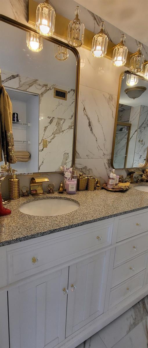 bathroom with vanity and tile walls