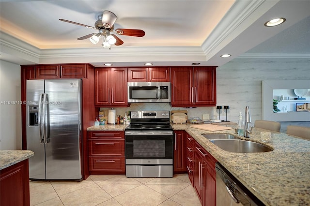 kitchen with appliances with stainless steel finishes, crown molding, sink, and light stone counters