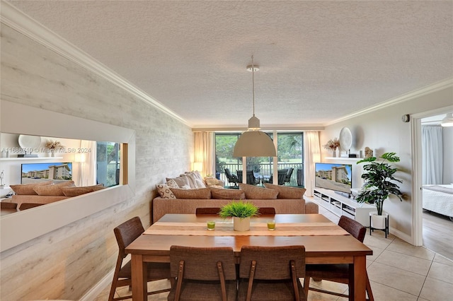 tiled dining room with ornamental molding and a textured ceiling