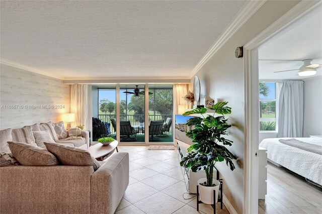 living room featuring light hardwood / wood-style floors, a textured ceiling, plenty of natural light, and ceiling fan