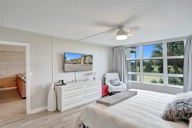 bedroom featuring a textured ceiling, light hardwood / wood-style floors, and ceiling fan