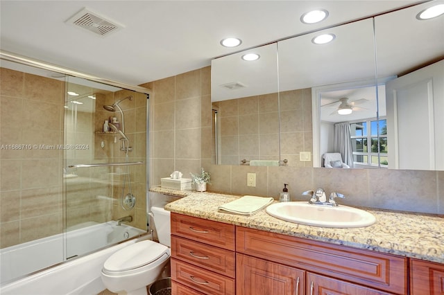 full bathroom featuring enclosed tub / shower combo, ceiling fan, tile walls, toilet, and vanity