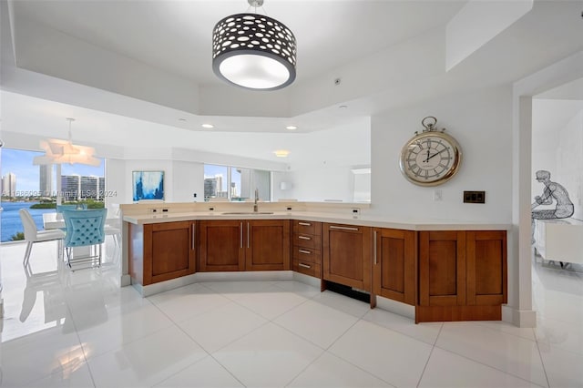 kitchen featuring sink, decorative light fixtures, light tile patterned floors, and a healthy amount of sunlight