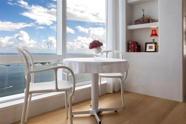 dining area featuring a water view and light wood-type flooring