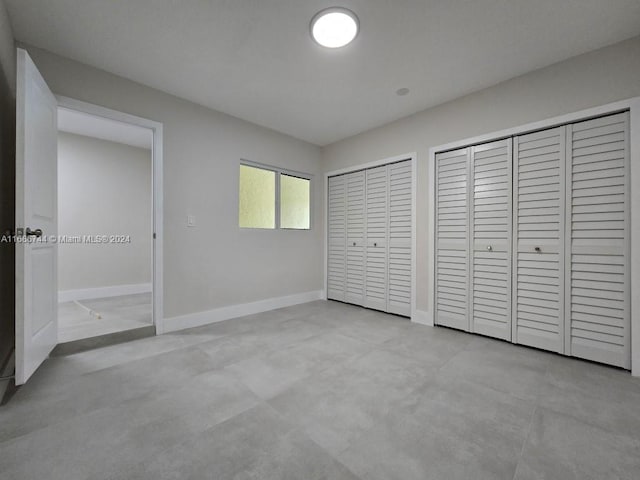 unfurnished bedroom featuring two closets