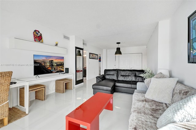 living room with light tile patterned flooring and a textured ceiling