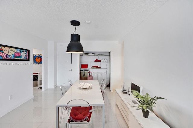 tiled dining space with a textured ceiling