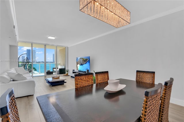 dining area featuring expansive windows, hardwood / wood-style floors, a water view, and crown molding