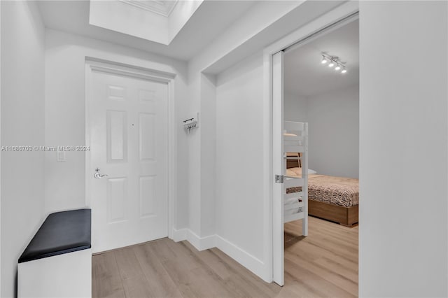 corridor featuring rail lighting and light hardwood / wood-style flooring