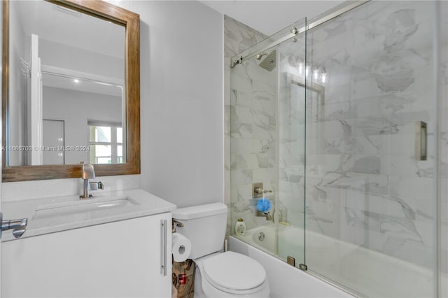 full bathroom with vanity, toilet, and enclosed tub / shower combo