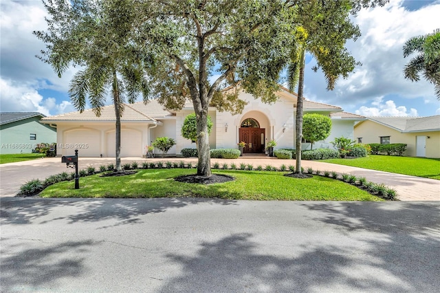 view of front of home with a garage and a front lawn