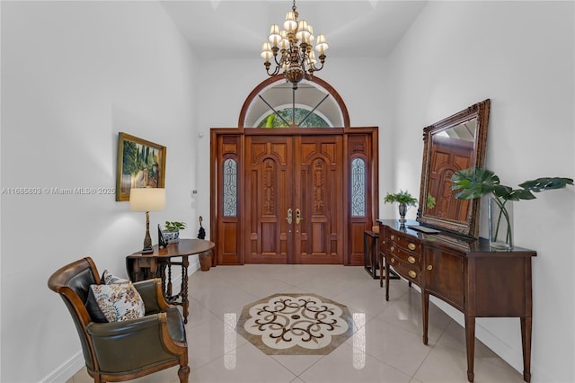 tiled foyer featuring a towering ceiling and an inviting chandelier