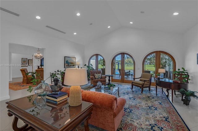 tiled living room with a notable chandelier, a healthy amount of sunlight, high vaulted ceiling, and french doors