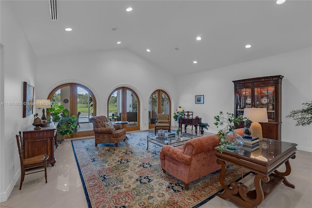 living room with light tile patterned floors, high vaulted ceiling, and french doors