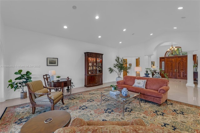 living room featuring a chandelier, decorative columns, and high vaulted ceiling