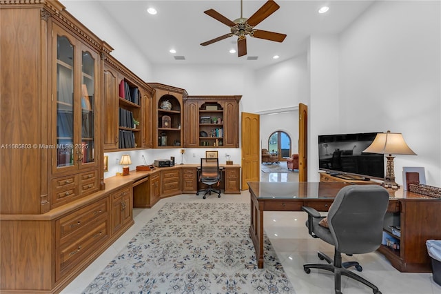 tiled office featuring a towering ceiling and ceiling fan